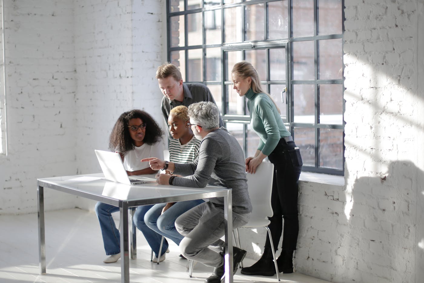 Digital strategy team collaborating around a laptop